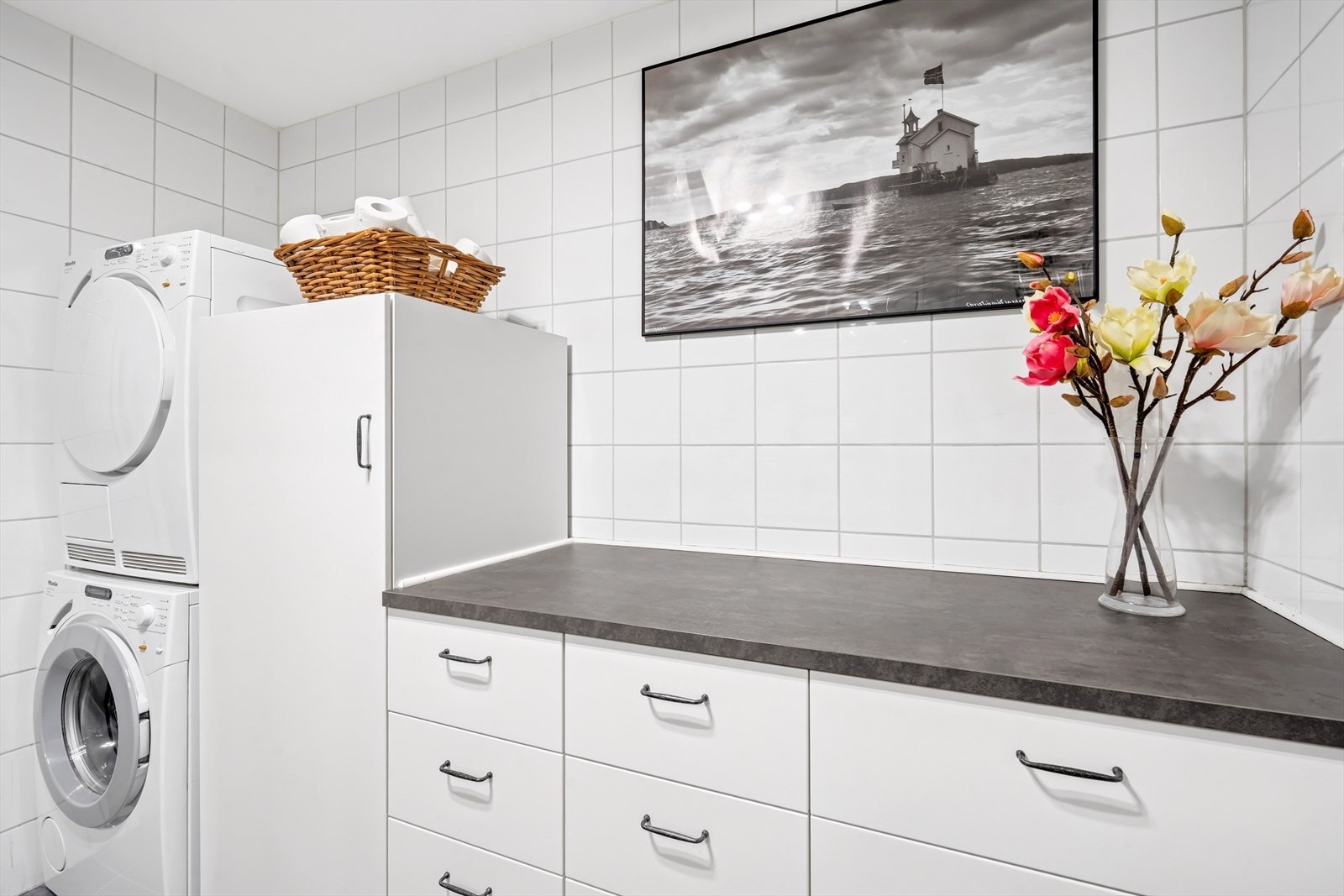 Videre er det regnfallsdusj med innfellbare glassdører, vegghengt toalett og god plass vaskemaskin og tørketrommel, samt rikelig med skapplass. Galleribilde