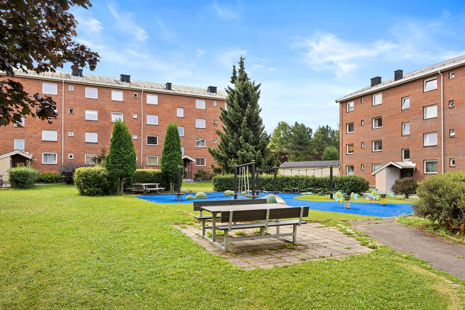 Fellesarealene er pent opparbeidet med prydbusker, plener, asfalterte internveier, sittegrupper og lekeapparater. Galleribilde