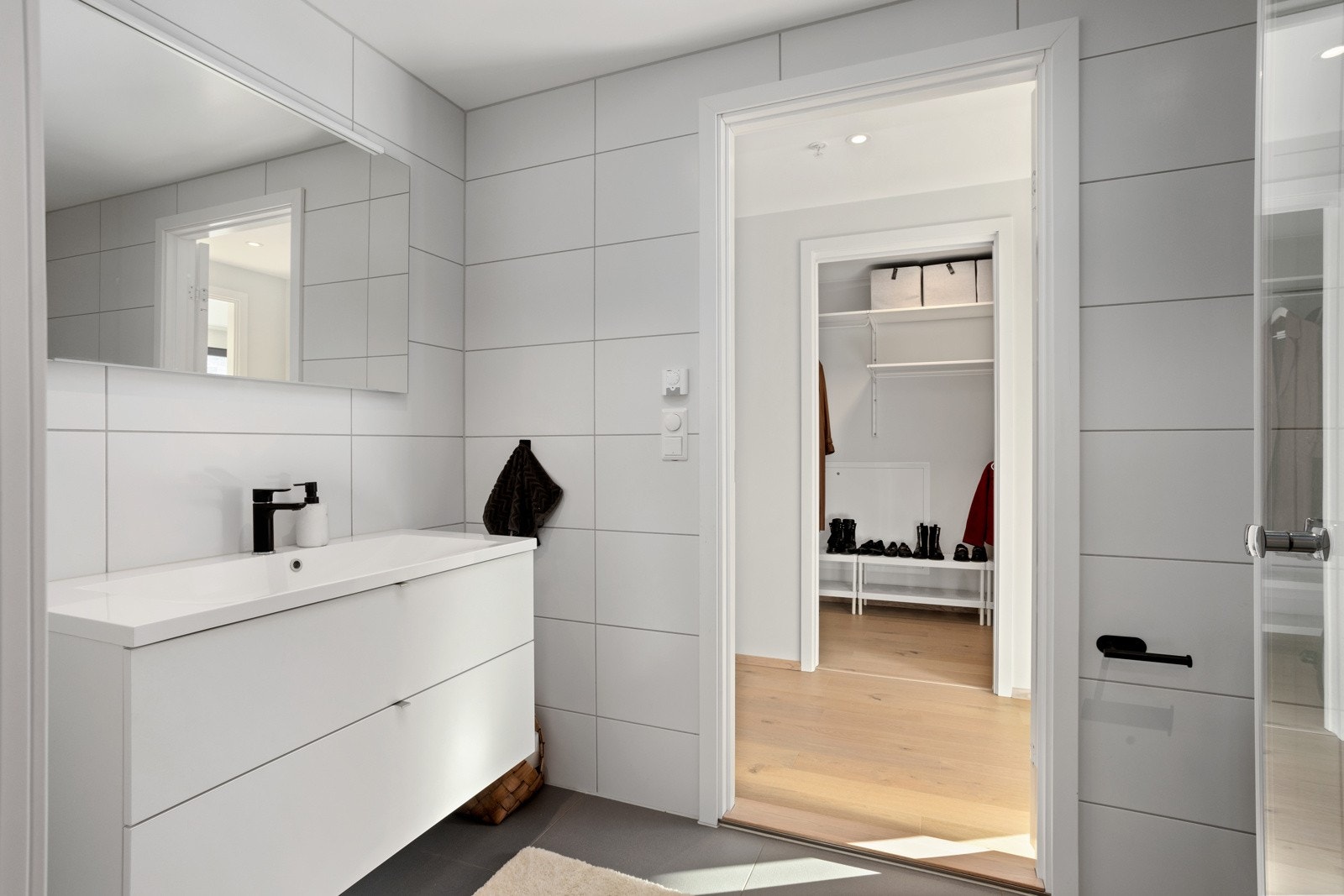 Gjestebad/wc med dusj og skapinnredning | tilstøtende vaskerom via skyvedør Galleribilde