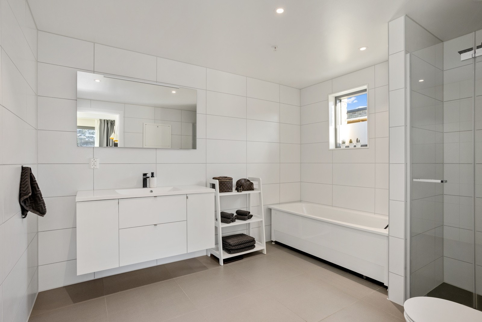 Bad/wc i tilknytning til masterbedroom med dusj, skapinnredning og badekar Galleribilde