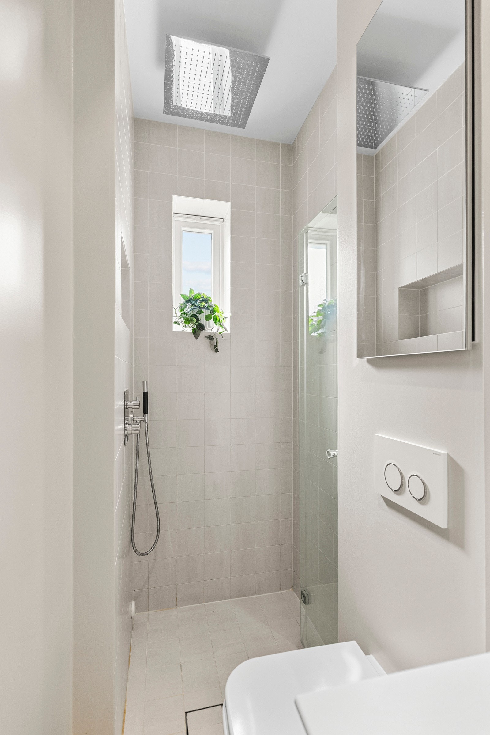 Badet har flislagt gulv med varmekabler og flis i dusjsonen, mens veggene utenfor dusjen er malt. Det er ventilasjon via mekanisk vifte og lufting under døren. Galleribilde