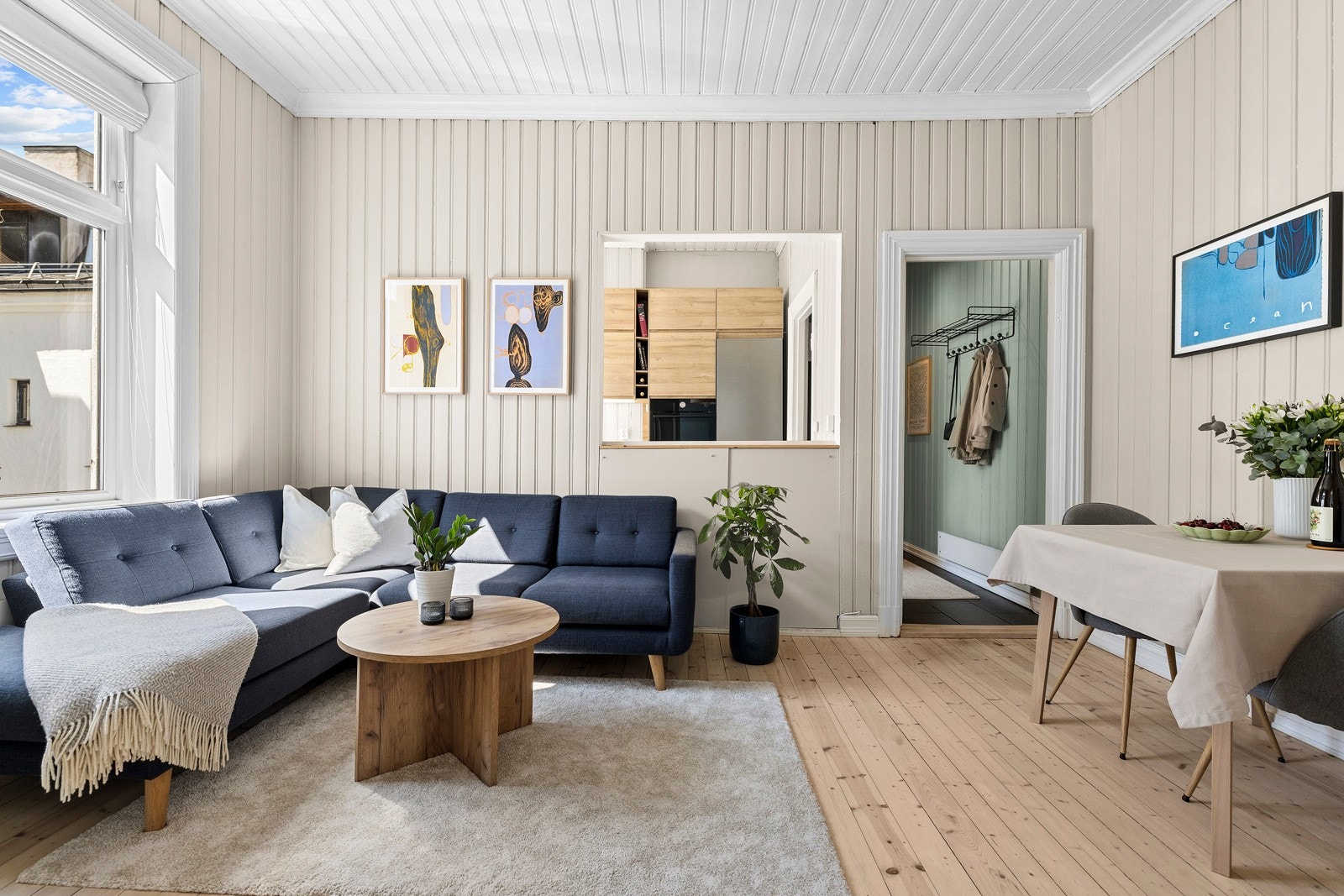 Leiligheten har originale tregulv, mens veggene er malt i lyse toner som bidrar til et lyst og praktisk oppholdsrom. Gulvene ble slipt i 2023. Galleribilde