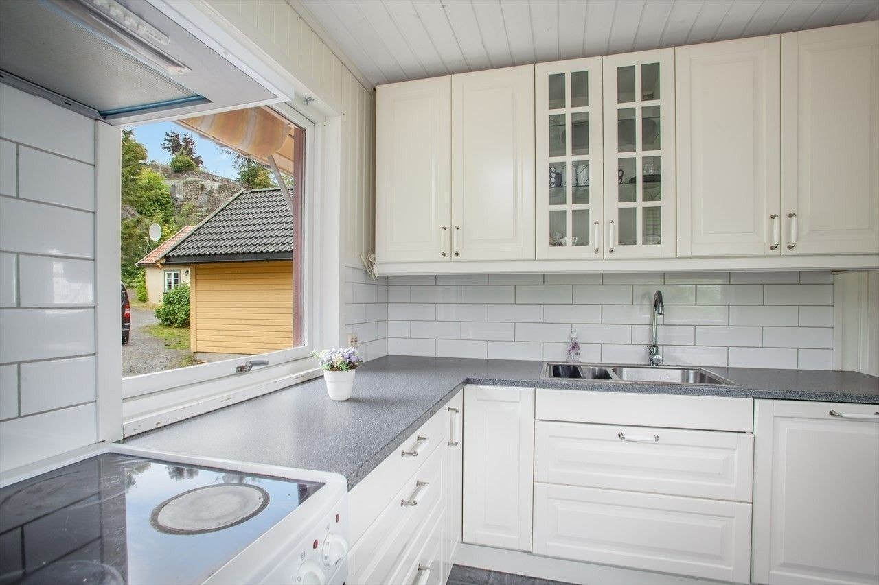 Kjøkken med hvitevarer og spiseplass. Galleribilde