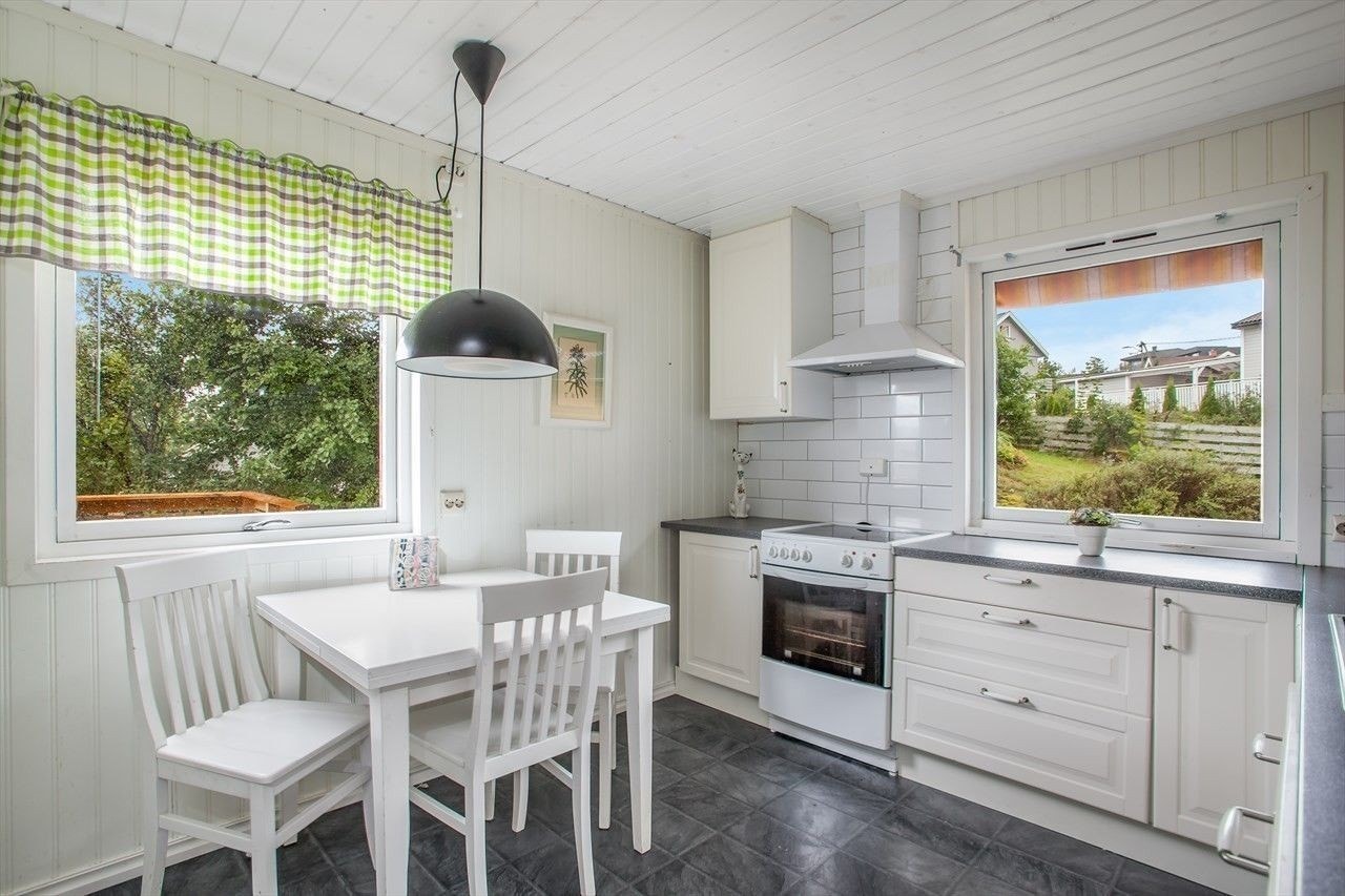 Kjøkken med hvitevarer og spiseplass. Galleribilde