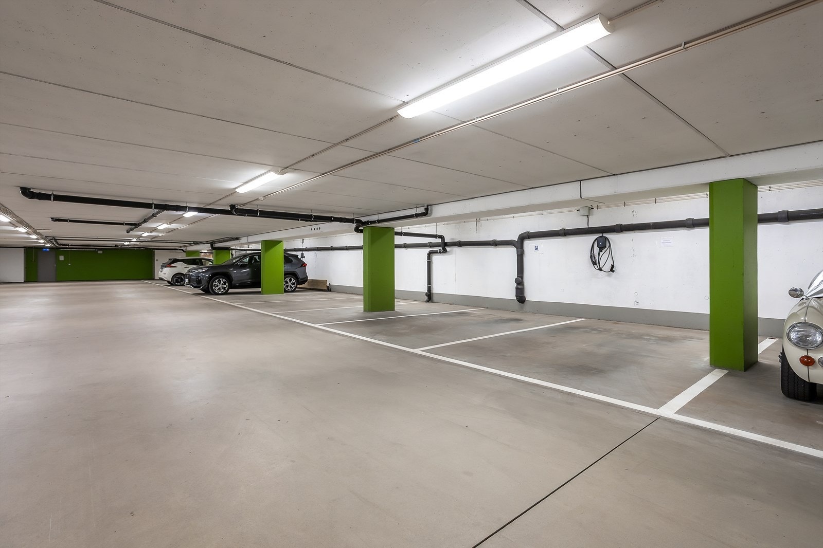 Leilighetens parkeringsplass er til høyre i bilde med egen el-billader - bred og fin p-plass. Kort vei til 5 kvm sportsbod Galleribilde
