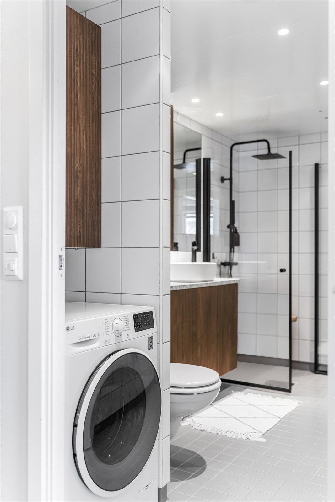 Praktisk vaskesone på badet med plass til både vaskemaskin og oppbevaring. Galleribilde