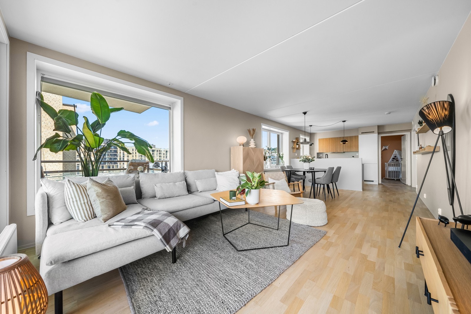 Åpen stue- og kjøkkenløsning med gjennomgående parkett og moderne fargevalg. Galleribilde