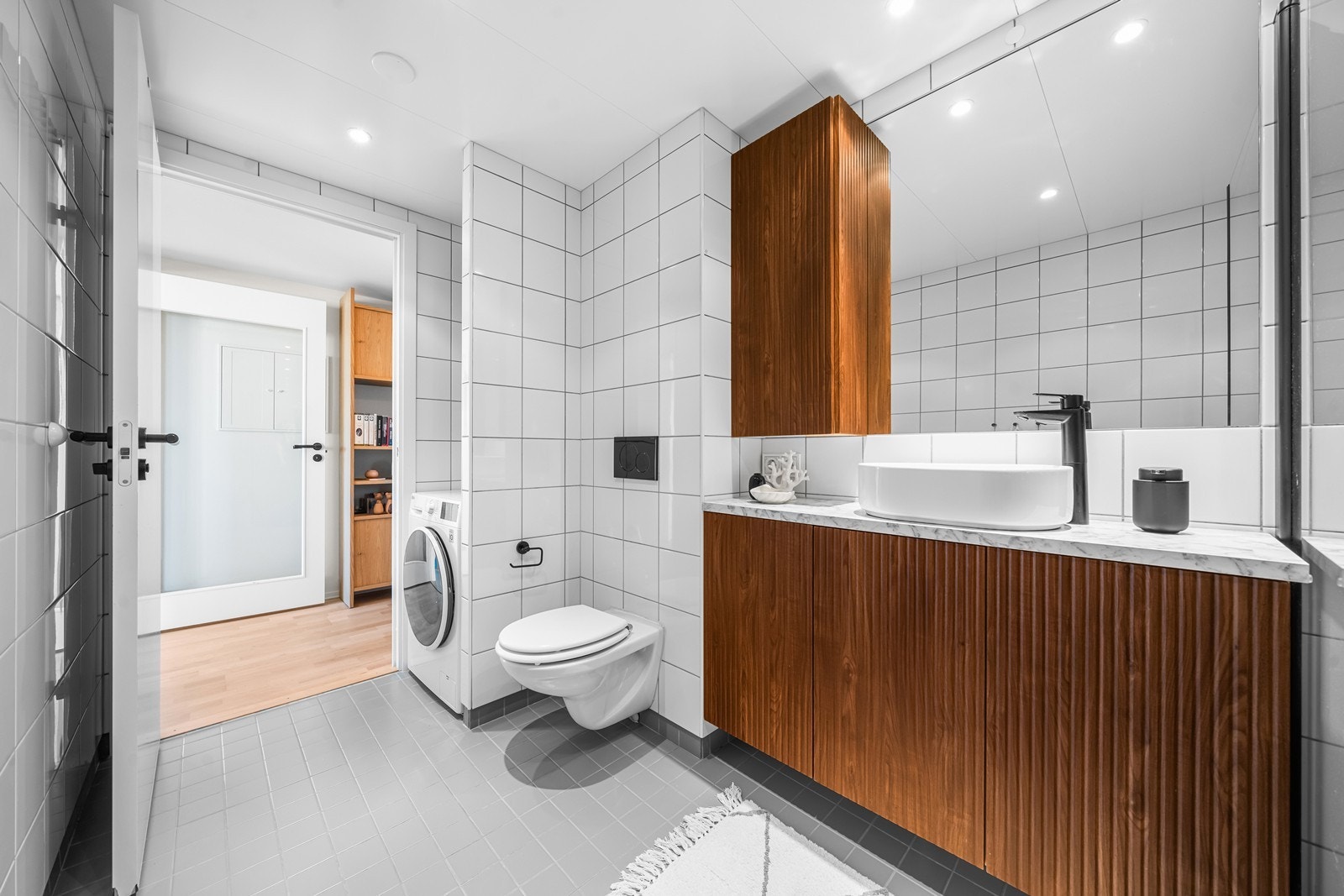 Badet har både vaskemaskinopplegg og moderne innredning med rikelig oppbevaringsplass. Galleribilde