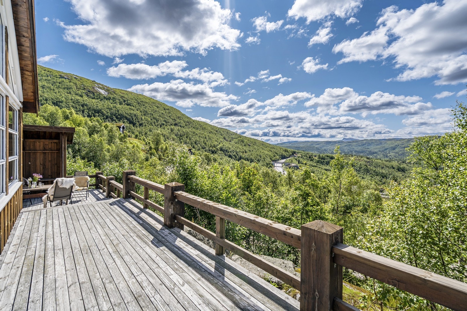 Terrasser som omkranser tre sider av hytten Galleribilde