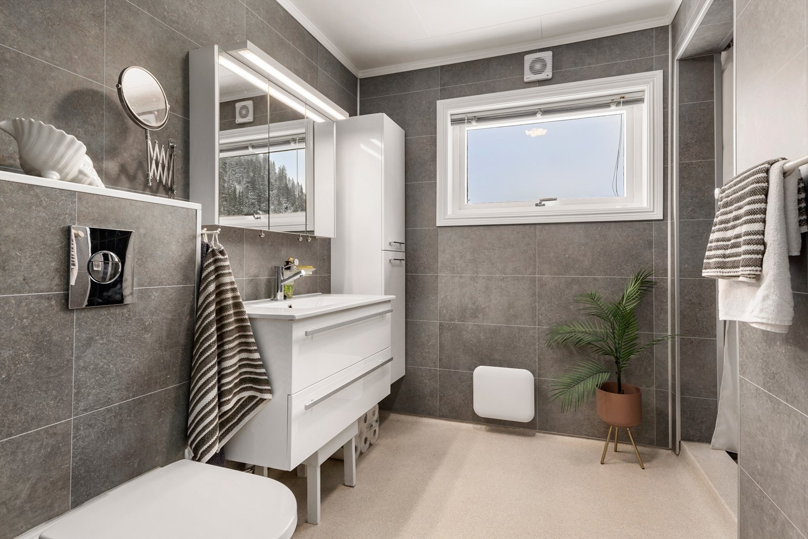 Badet ble oppusset i 2021 med tidløse våtromsplater på veggene og belegg på gulvet, samt en dusjnisje og god plass. Galleribilde