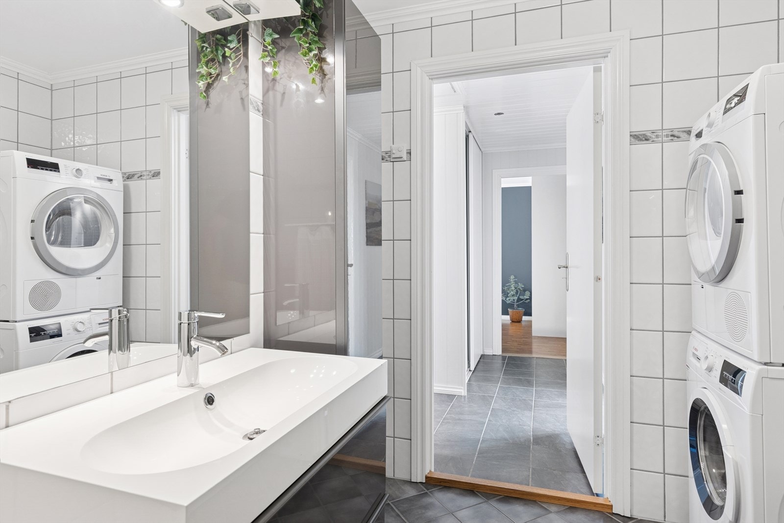 Badet er innredet med et toalett, baderomsinnredning med servant og dusjkabinett. Galleribilde