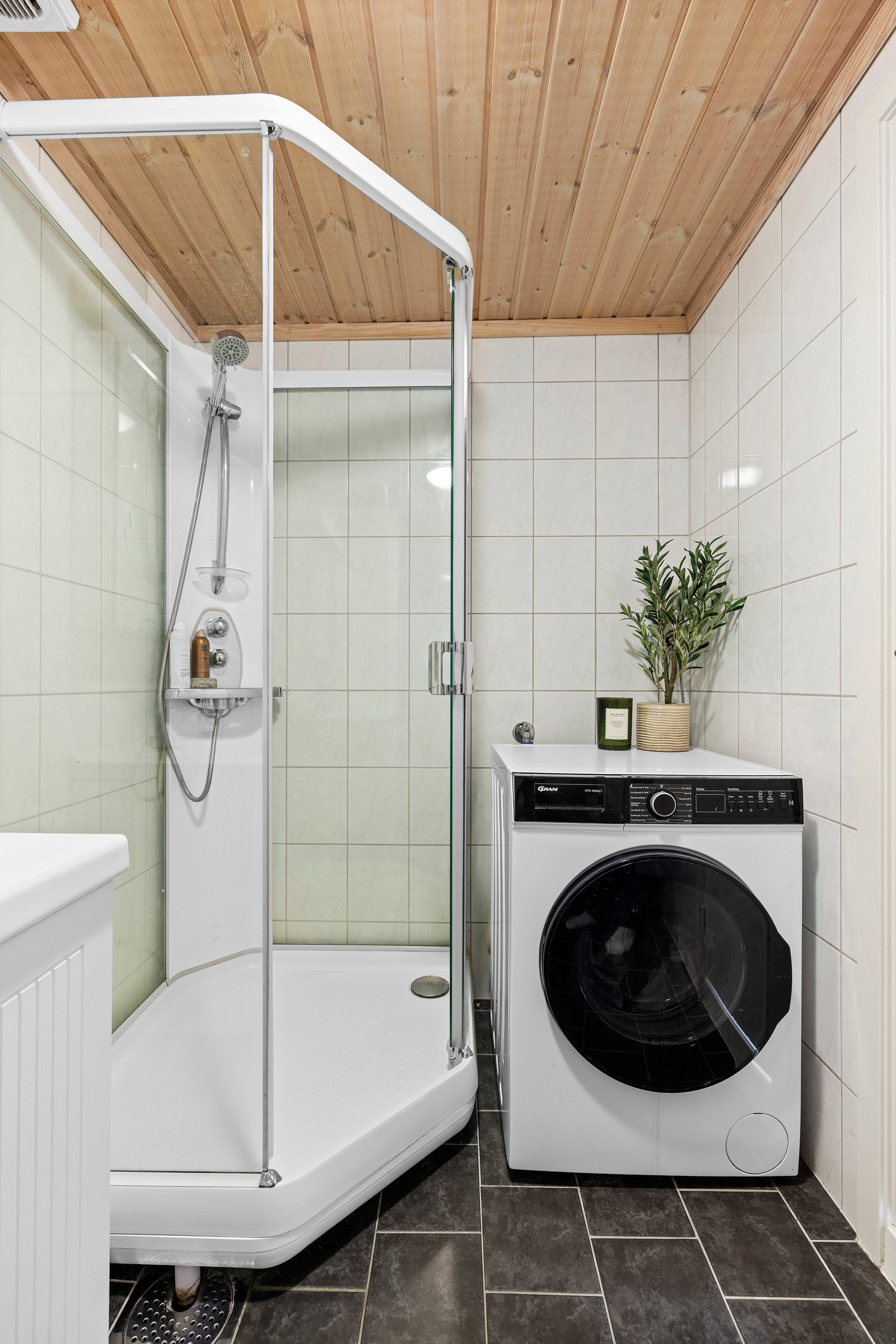 Badet har dusjkabinett, servant i innredning, speil, toalett og opplegg for vaskemaskin/tørketrommel Galleribilde