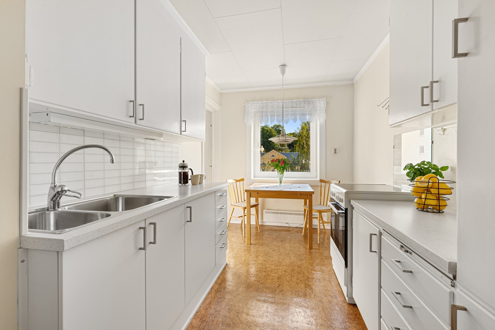 Lyst kjøkken med mye skap -og benkeplass. Galleribilde