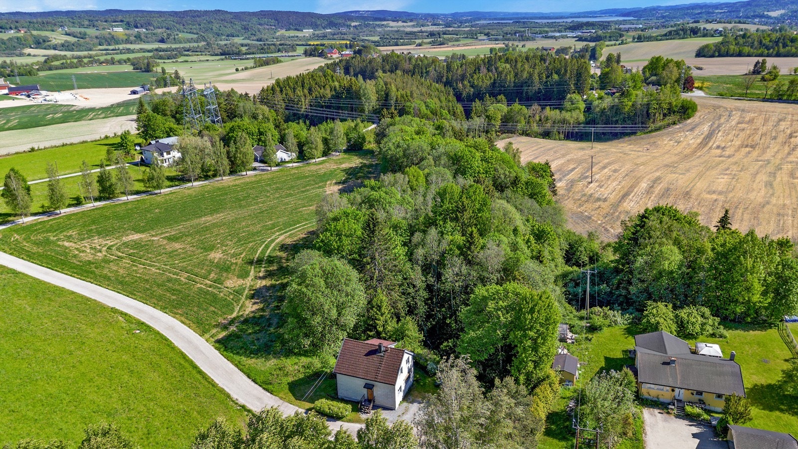 Huset ligger like i et skogholt, omgitt av landlige omgivelser Galleribilde