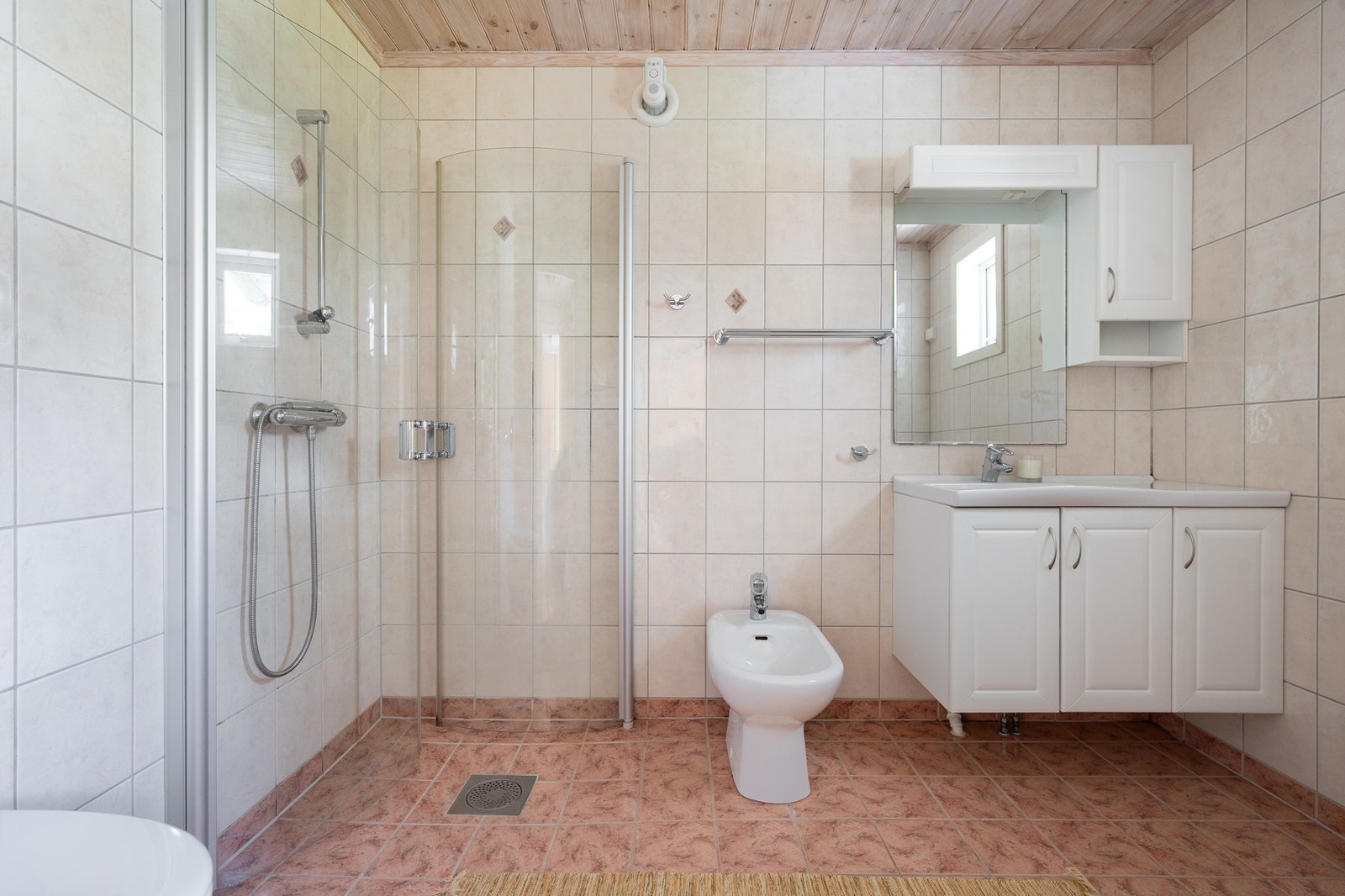 Badet er romslig med fliser på gulv og vegger. Galleribilde