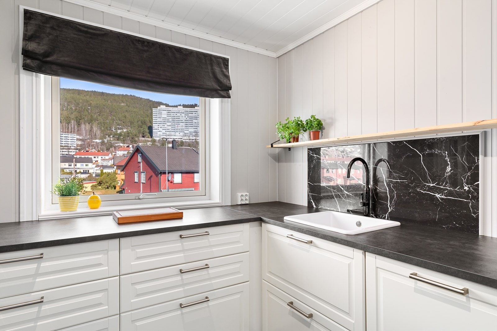 Kjøkkenet er utstyrt med integrerte hvitevarer og benkeplate i laminat Galleribilde