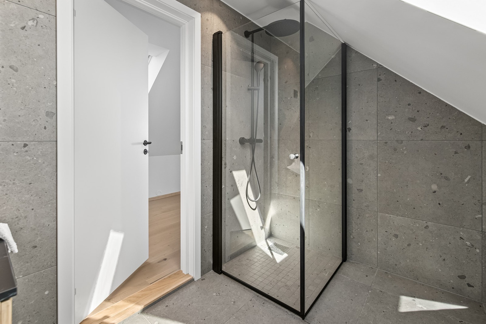 Dusjhjørne med glassdører og pene svarte detaljer. Galleribilde