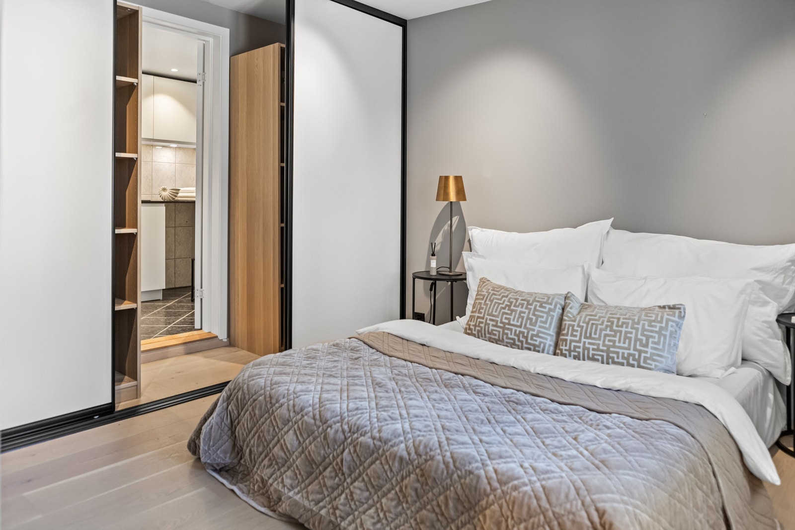 Skyvedørsgarderobe med inngang til et romslig bad og vaskerom. Galleribilde