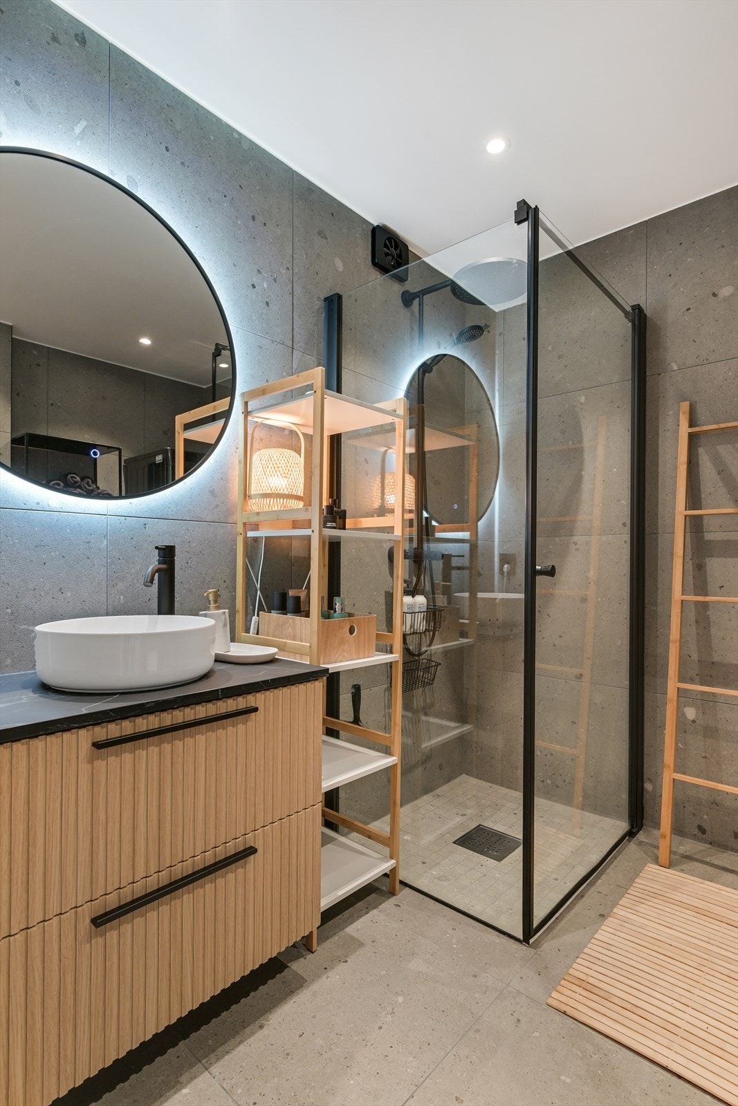 Badet er innredet med overliggende servant, veggmontert toalett, dusjvegger/hjørne og opplegg for vaskemaskin. Galleribilde