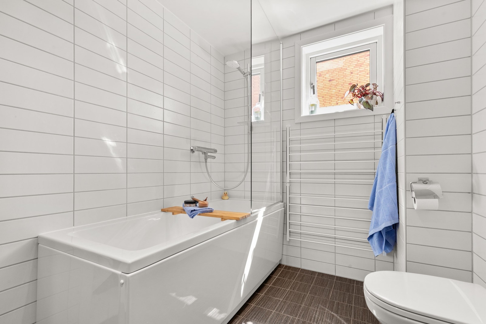 Videre har badet vegghengt klosett og badekar. Galleribilde