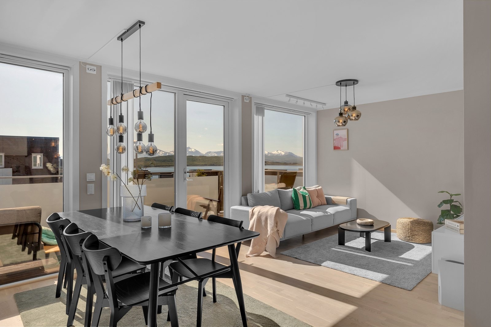 Lys og moderne stue med store vinduer som gir panoramautsikt over vakre fjell og sjø Galleribilde