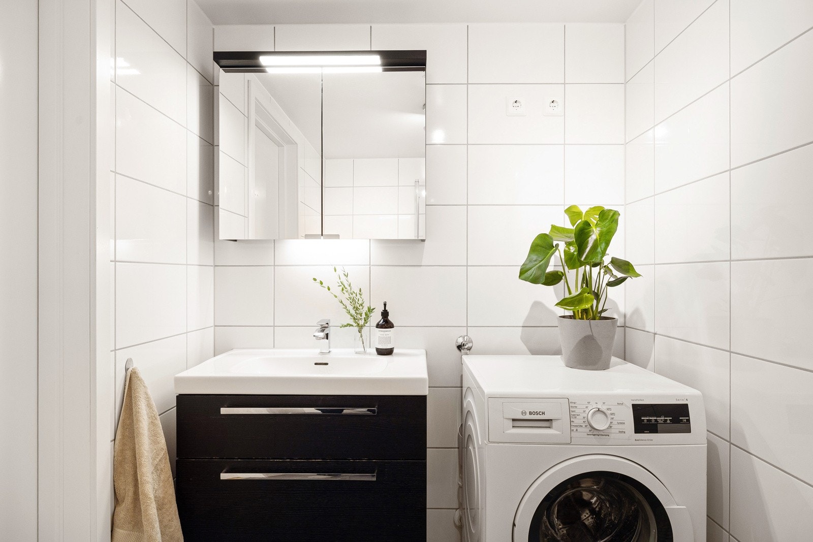 Badet har tidløst flisvalg og moderne innrending med skuffer og speilskap. Varmekabler på gulv og opplegg for vaskemaskin/tørketrommel. Galleribilde