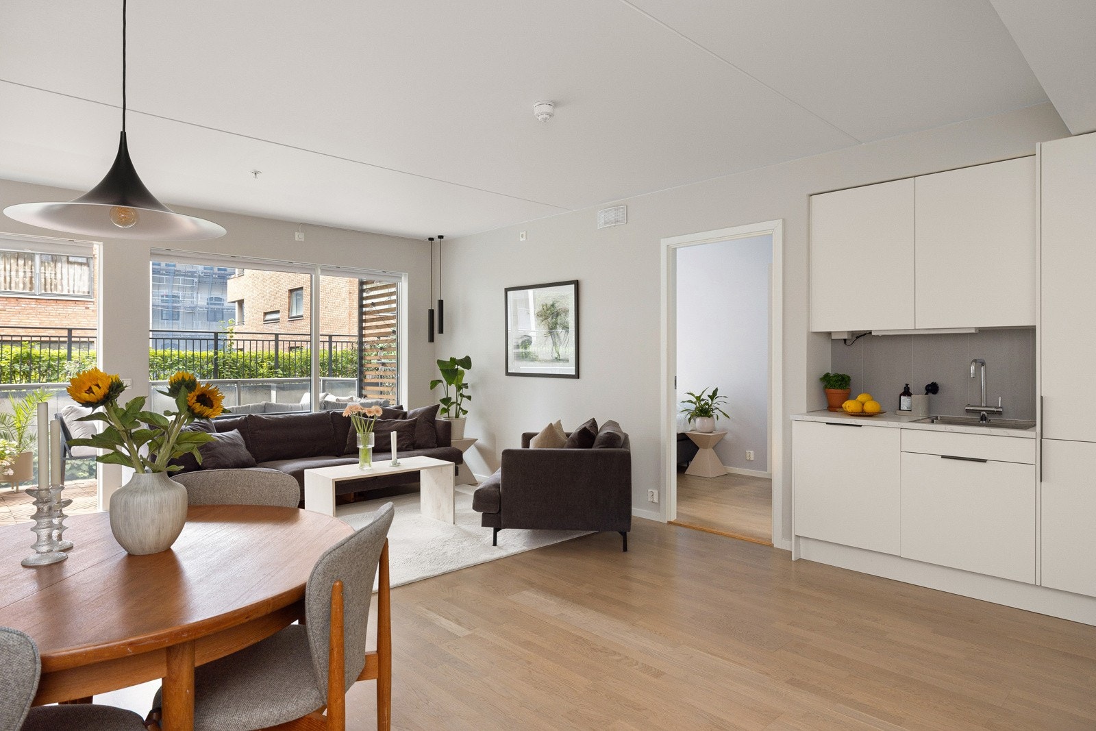 Den åpne løsningen mellom stuen og kjøkkenet er både sosial og praktisk. Galleribilde