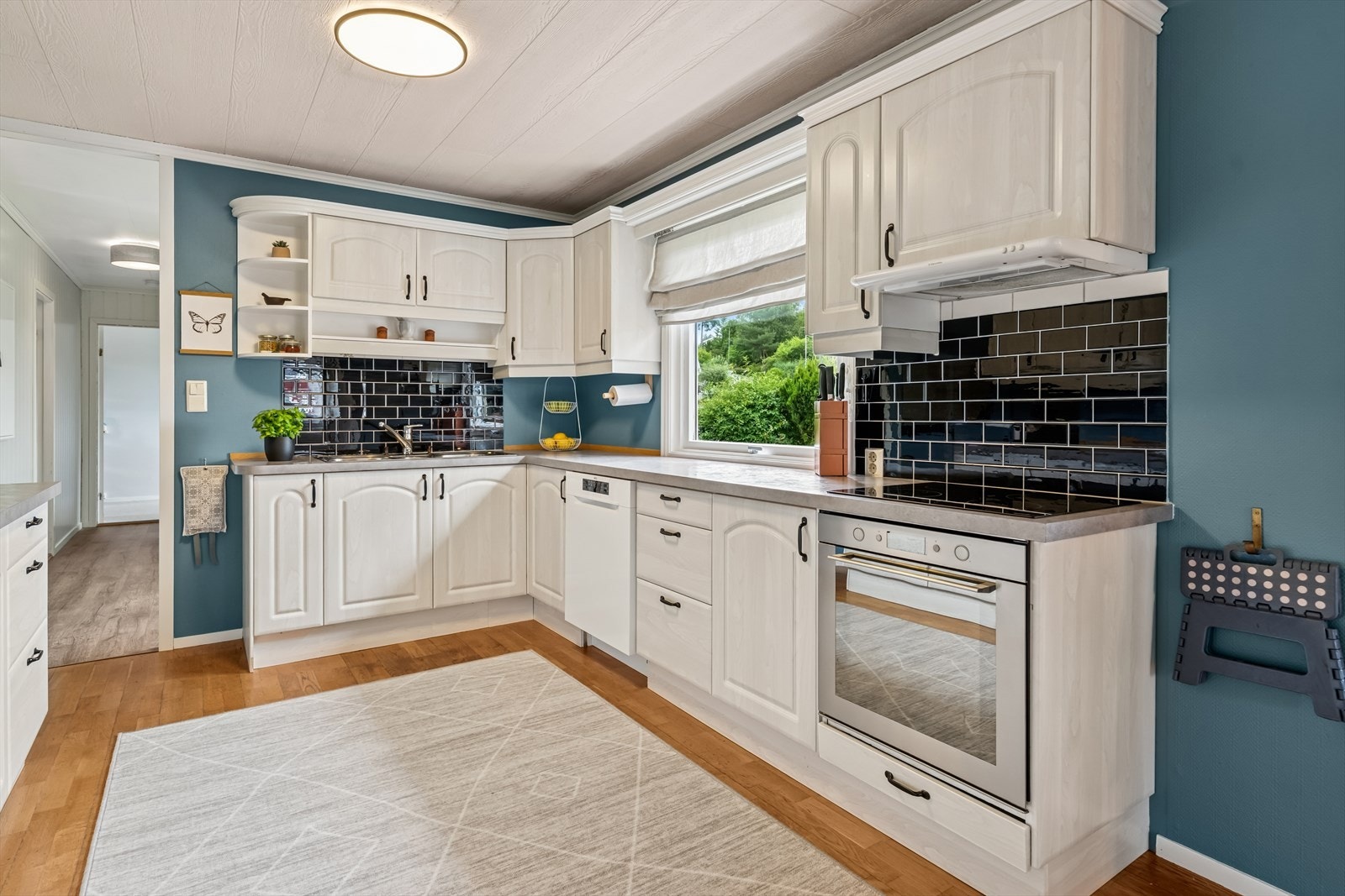 Kjøkkenet har innredning med profilerte fronter og folierte overflater. Benkeplaten er av laminat, og det er installert både komfyr og platetopp. Galleribilde