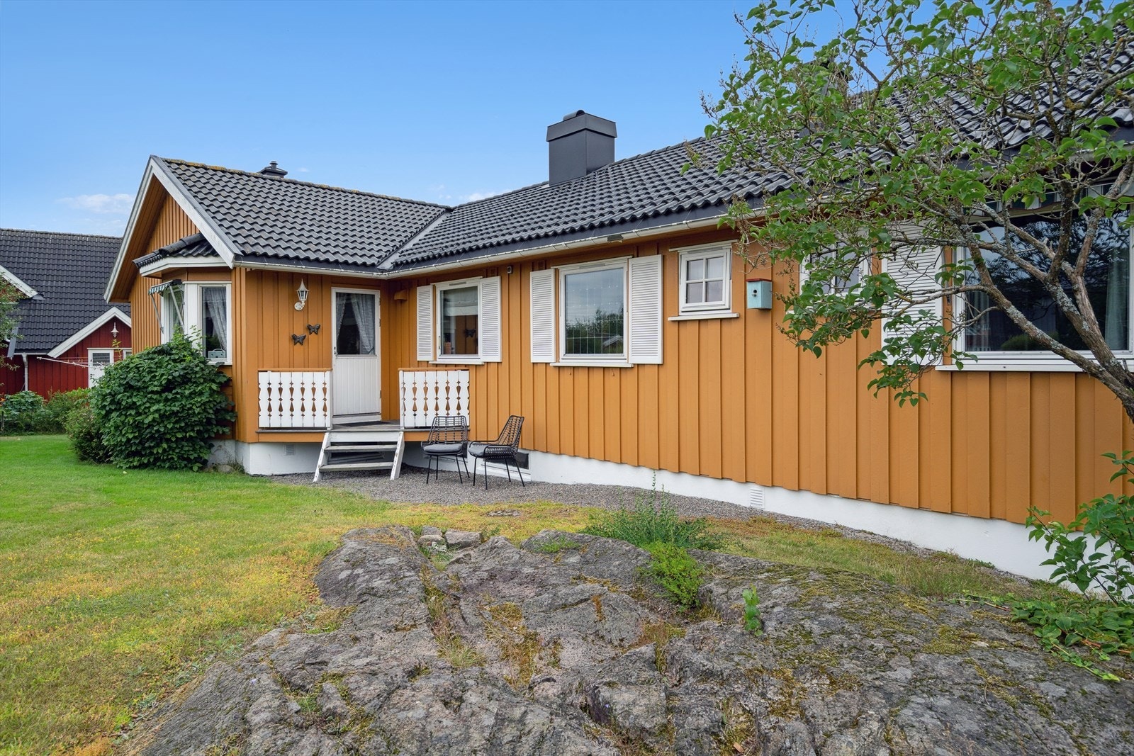 Meget pent opparbeidet tomt med sitteplasser, busker og beplantning. Galleribilde