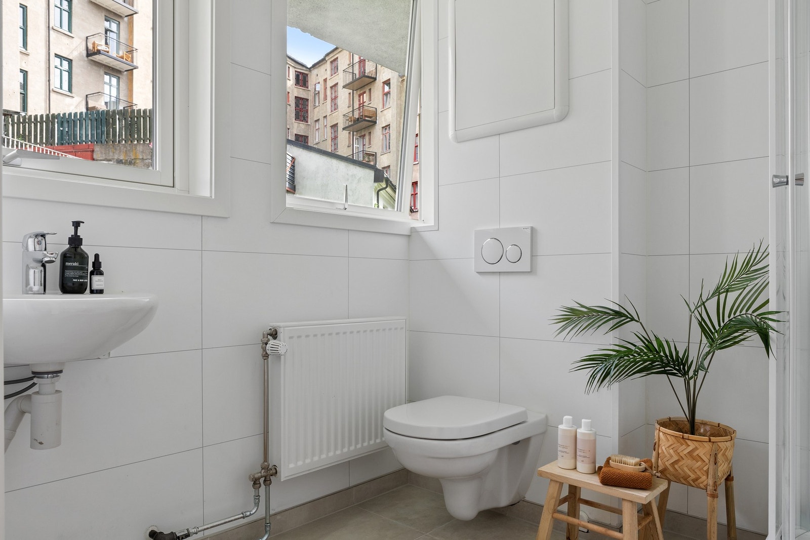 Et pent, stilrent baderom med vindu, vegghengt wc, servant og dusj. Galleribilde