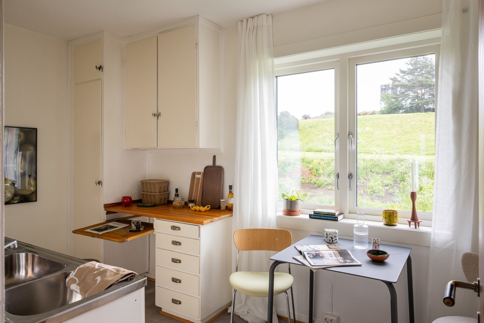 Eldre innredning med behov for modernisering. Originale skap med malte fronter og delvis nyere innredning med glatte, finerte fronter. Galleribilde