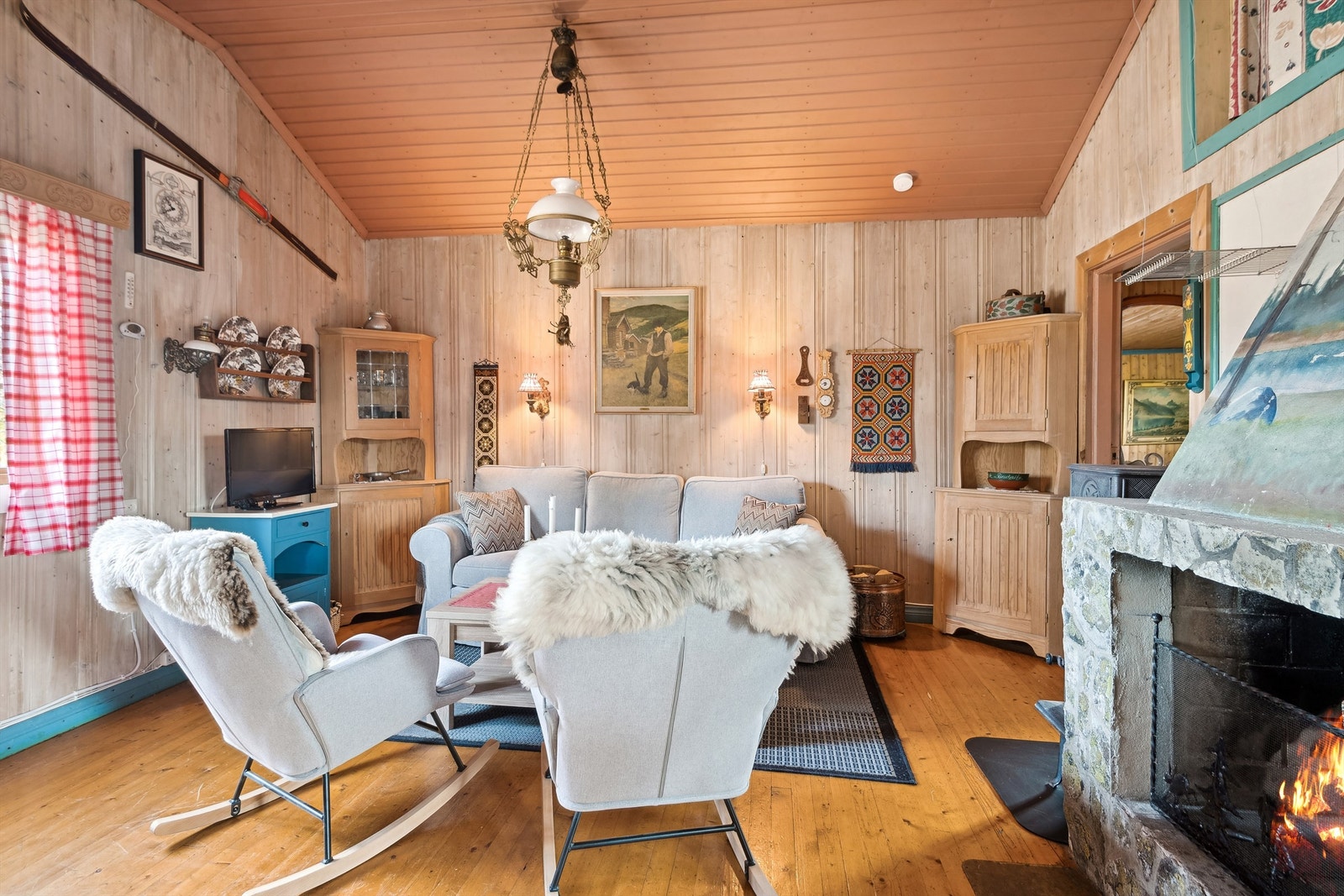 Stuen har furugulv, panelte vegger og skråtak Galleribilde