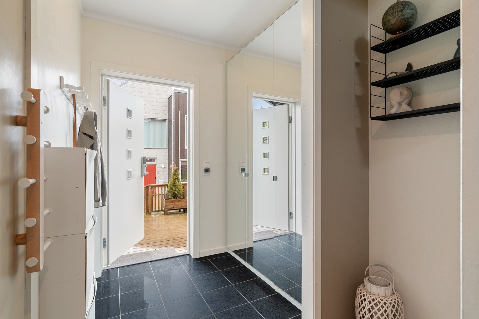 Du blir møtt av en romslig entré med flis på gulv med varme. Her er det god plass til oppbevaring i skap med speilfronter. Galleribilde