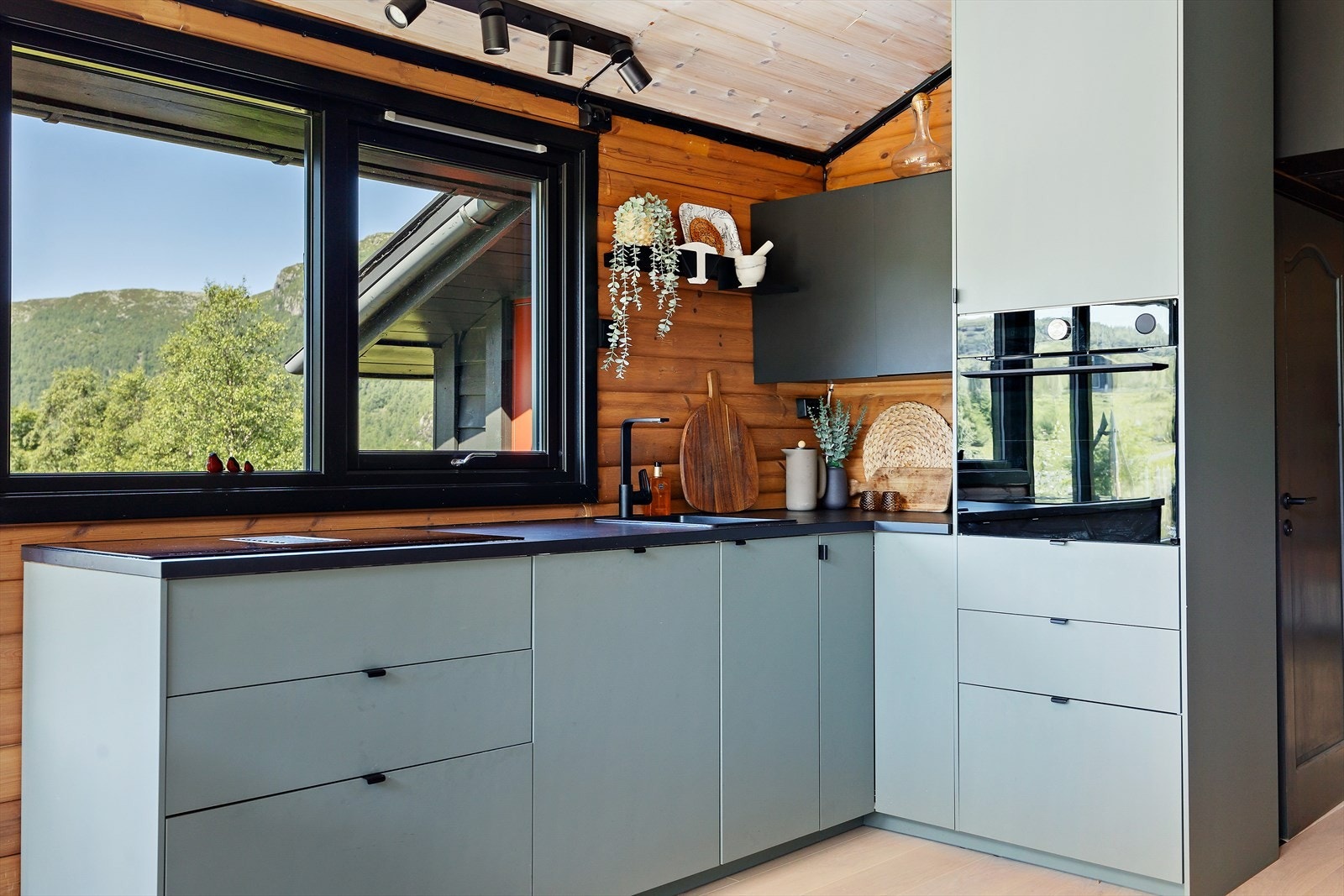 Et stilrent og moderne kjøkken med slette fronter og integrert oppvaskmaskin og komfyr. Galleribilde