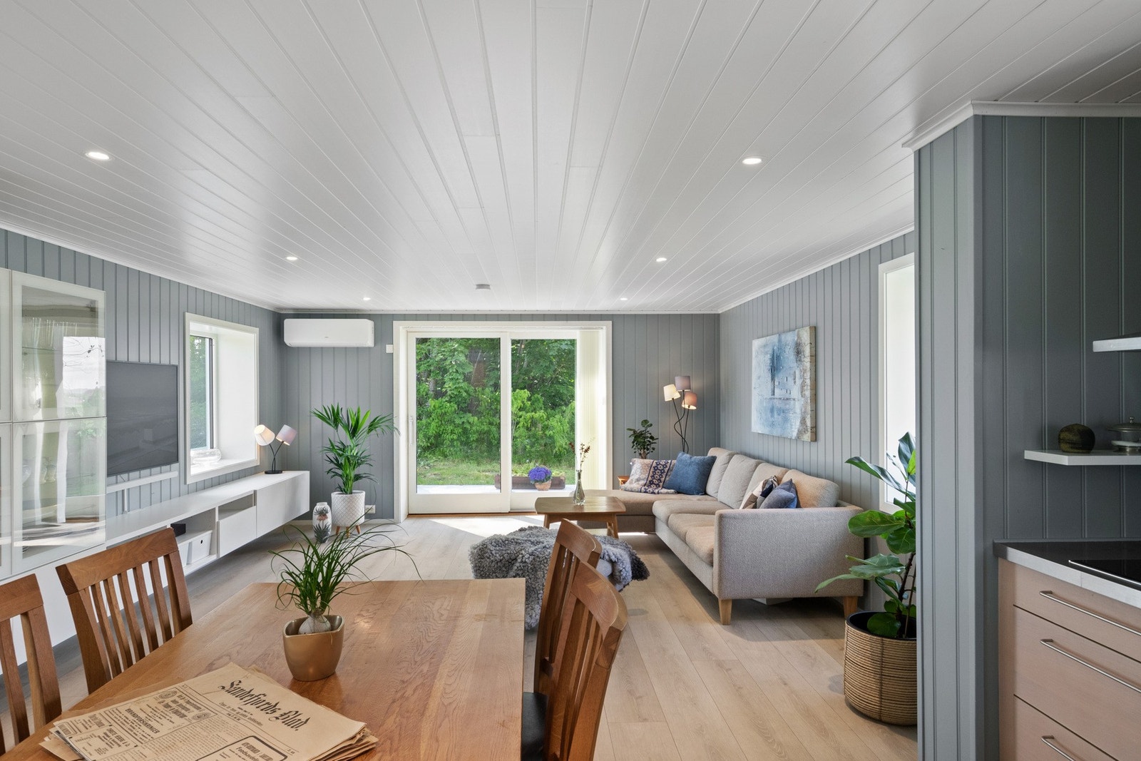 Sammen med kjøkkenet utgjør stuen et romslig og innbydende allrom, der vinduer i tre retninger sørger for fine lys- og utsiktsforhold. Galleribilde