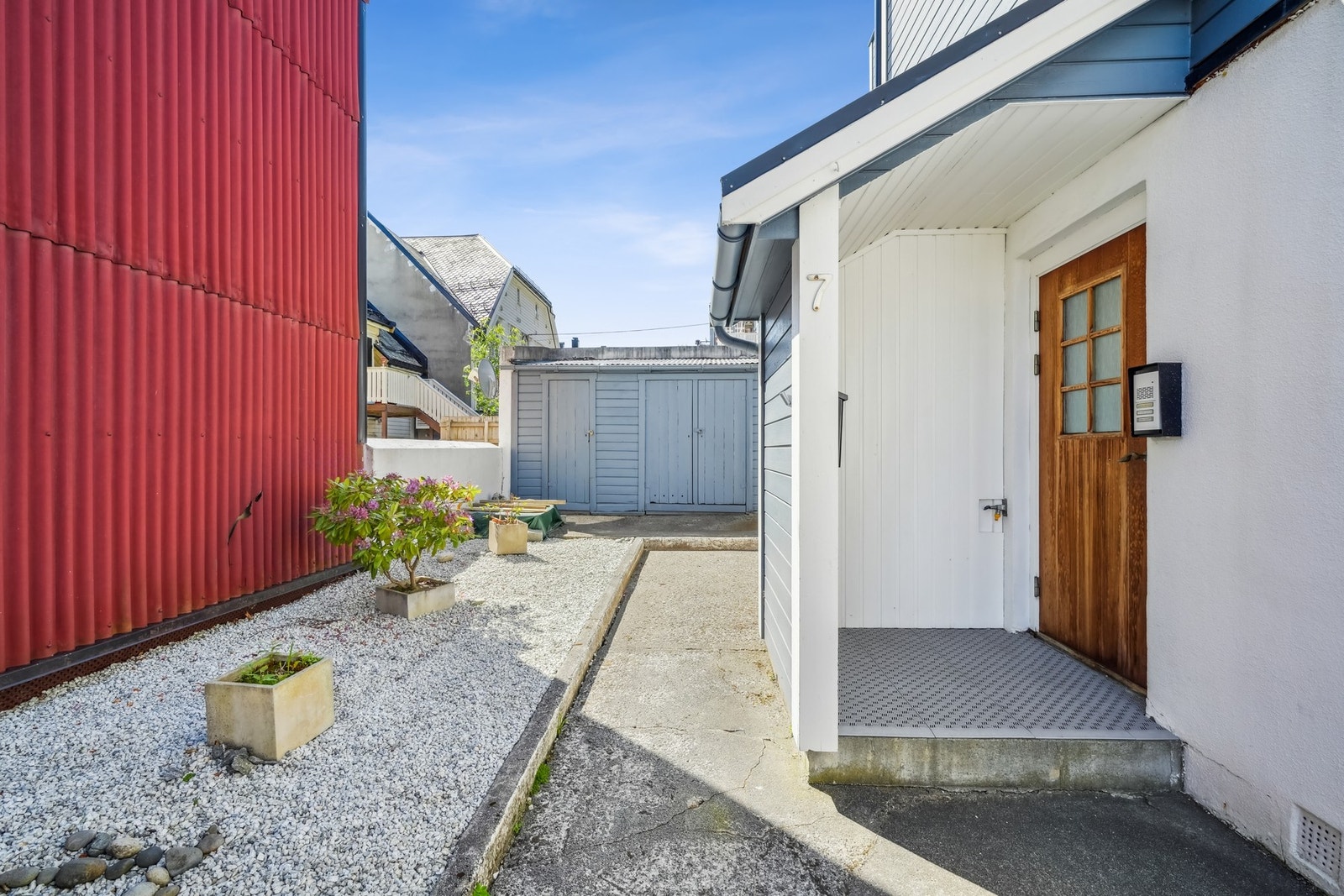 Inngangsparti til bygg. Utvendig bod avbildet i bakgrunnen. Galleribilde