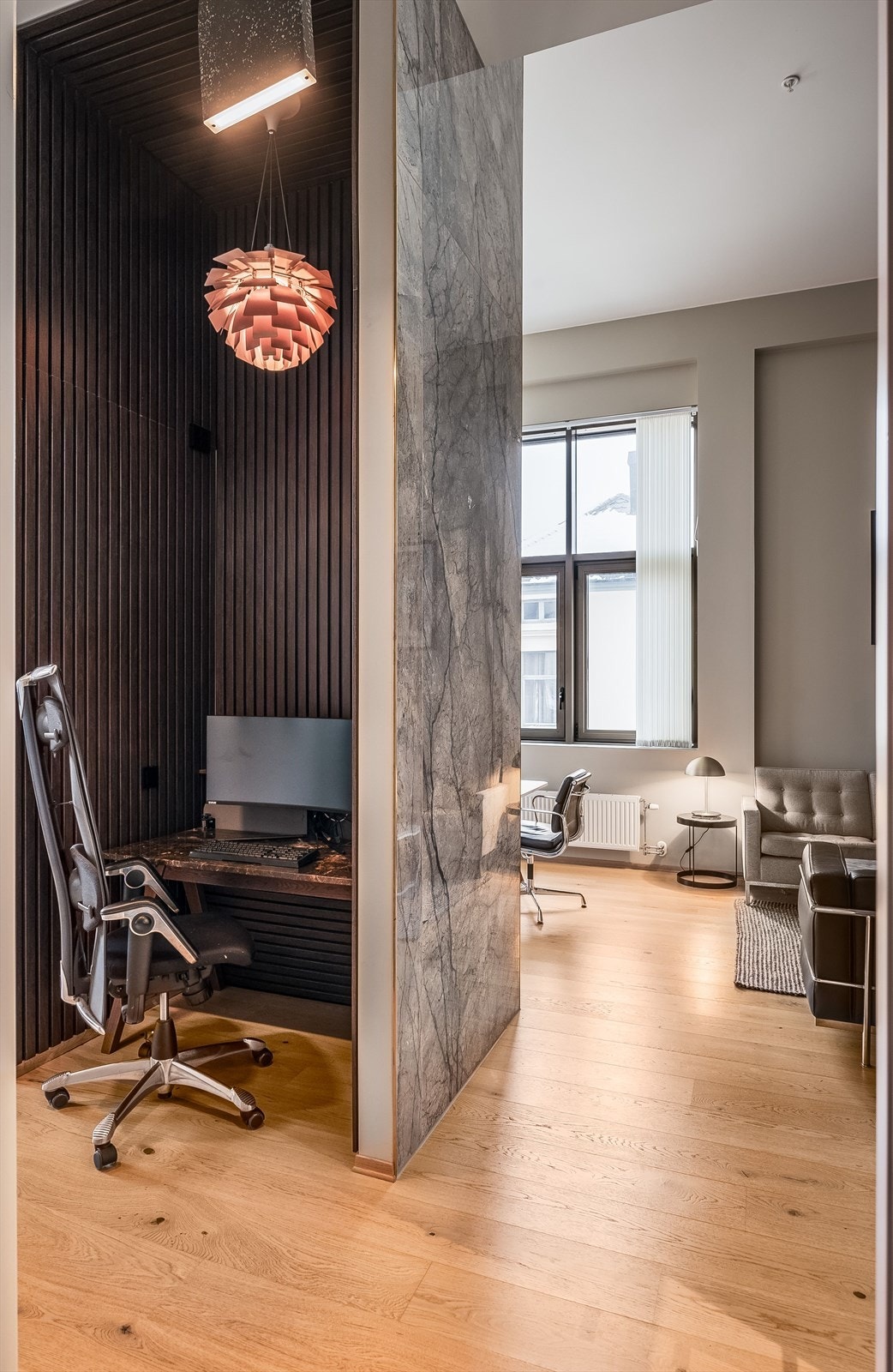 I midten av rommet er det bygget inn en liten kontorplass, utført med mørke spiler på innsiden. En lekker detalj som også deler stuen fra gangen. Galleribilde