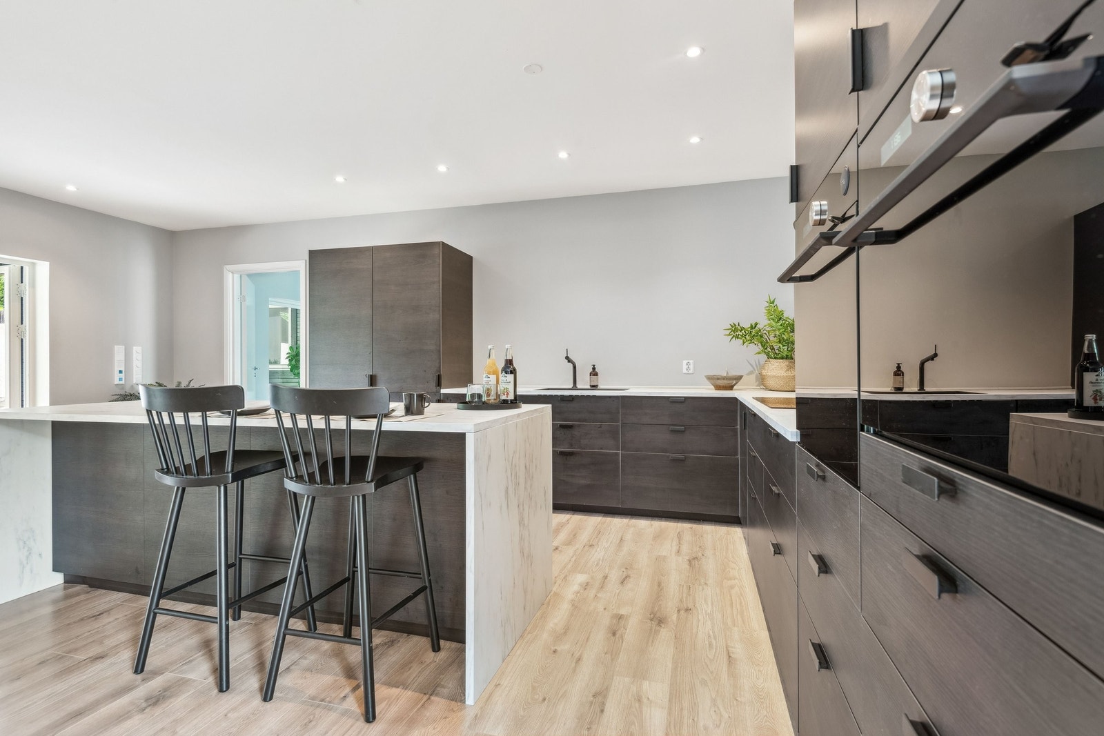 Ny og flott kjøkkeninnredning fra 2022 i hovedleiligheten, med slette fronter i sort utførelse og laminat benkeplate med nedfelt vask. Galleribilde