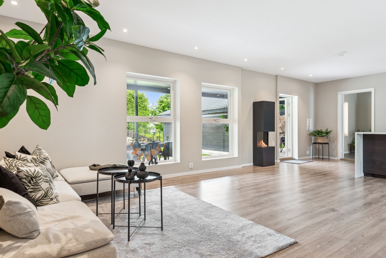 Stor kombinert stue/kjøkken i hovedleiligheten. Direkte adgang til uteplass med plen og stor uteplass under tak. Galleribilde