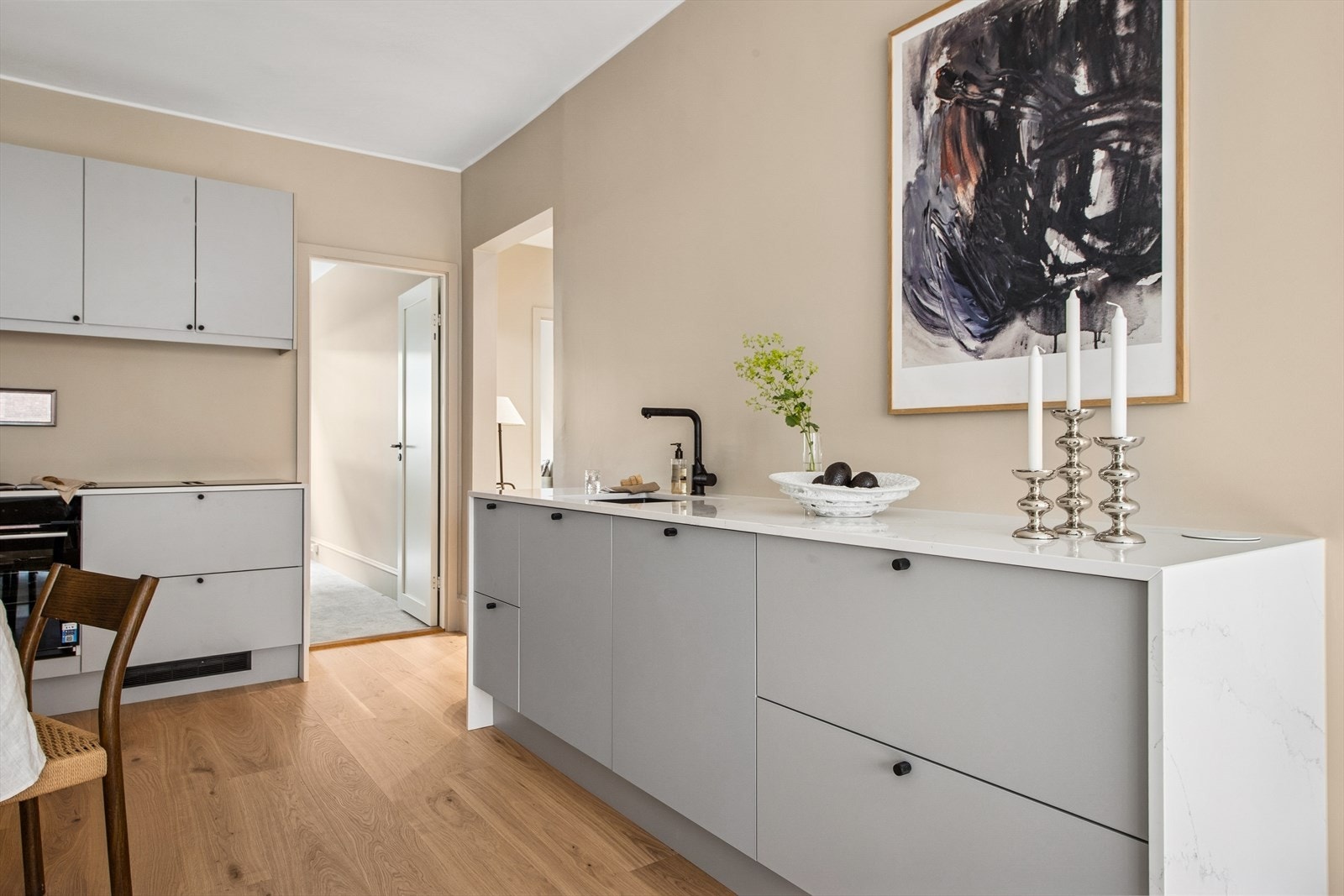Elegant kjøkken i åpen løsning mot stuen. Kjøkkenet har integrerte hvitevarer og platetoppen har integrert ventilator Galleribilde