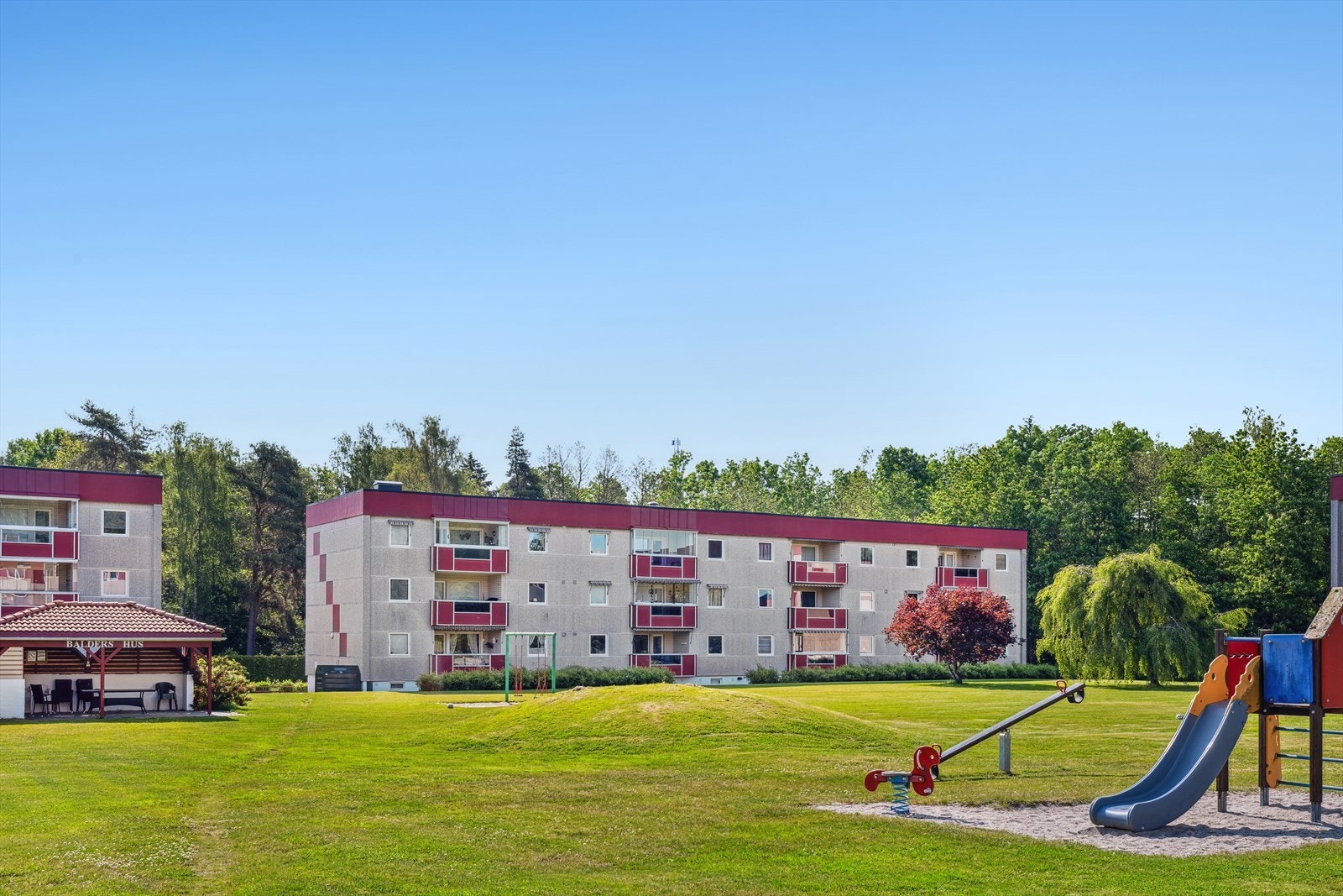 Meget pent opparbeidet og solrik tomt med store grøntarealer med sitteplasser og lekeplass med apparater. Galleribilde