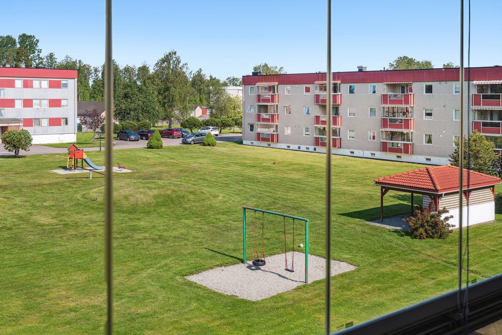 Meget pent opparbeidet og solrik tomt med store grøntarealer med sitteplasser og lekeplass med apparater. Galleribilde