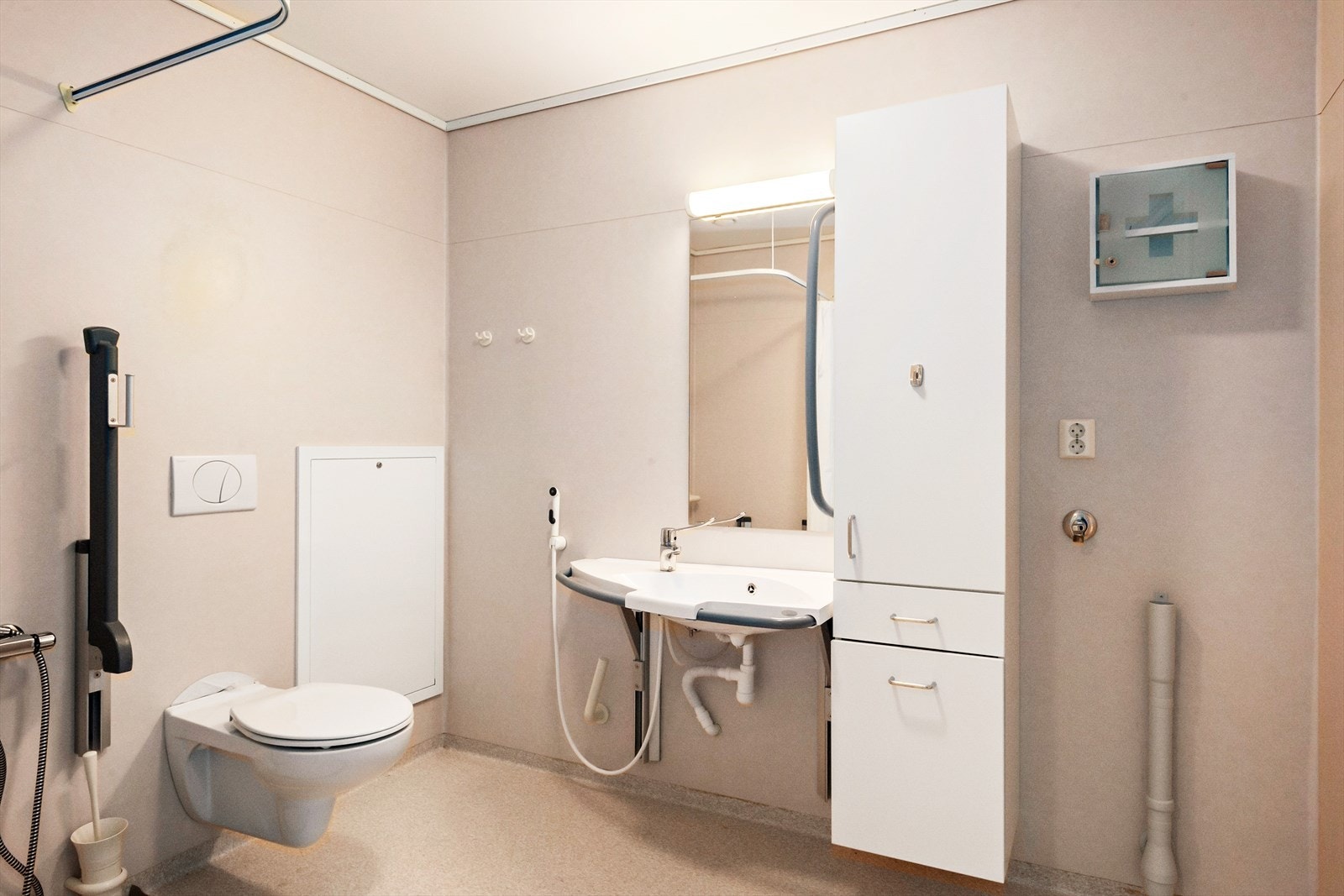 Praktisk, tilrettelagt bad med toalett, dusj, servant, innredning og opplegg for vaskemaskin. Galleribilde