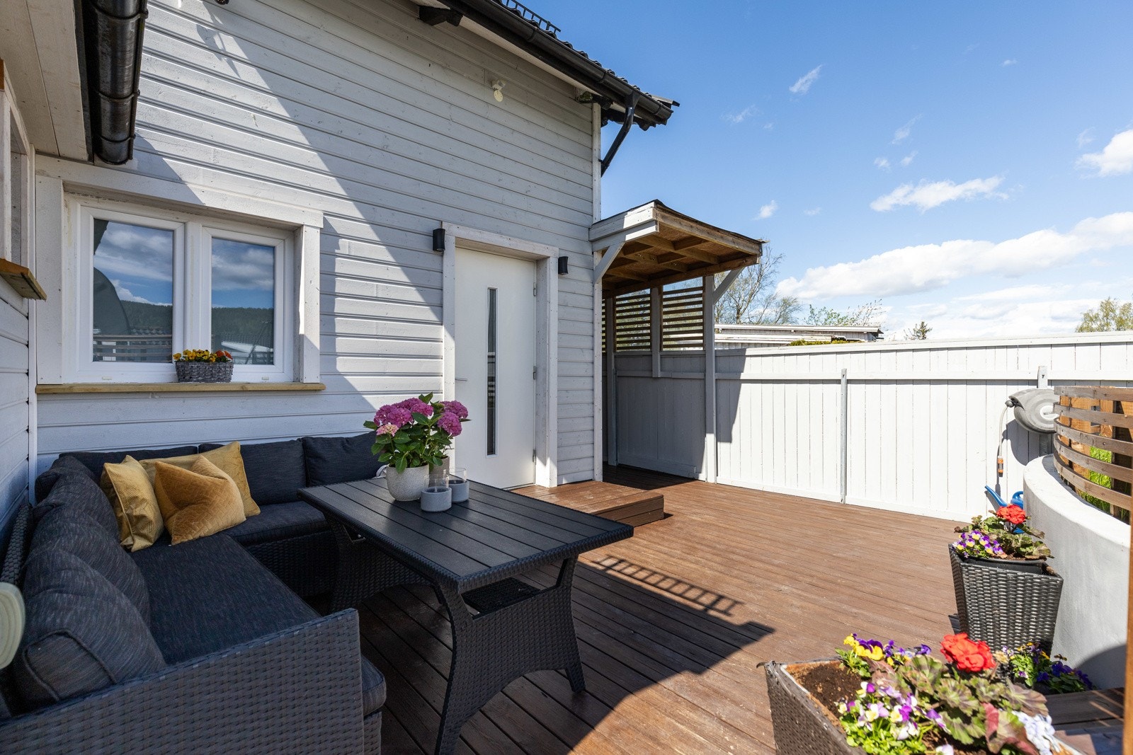 Terrassen er delvis overbygd, og har belysning, trapp til hagen og levegger for fin skjerming. Galleribilde