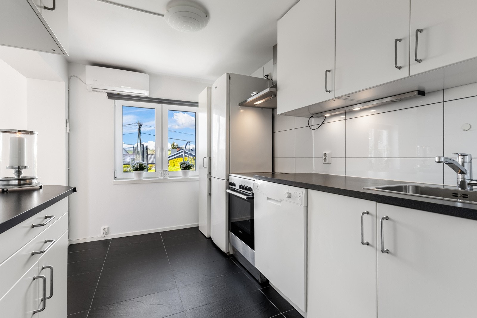 Ikea-innredningen har hvite, glatte fronter og laminert benkeplate med nedfelt oppvaskkum. Galleribilde
