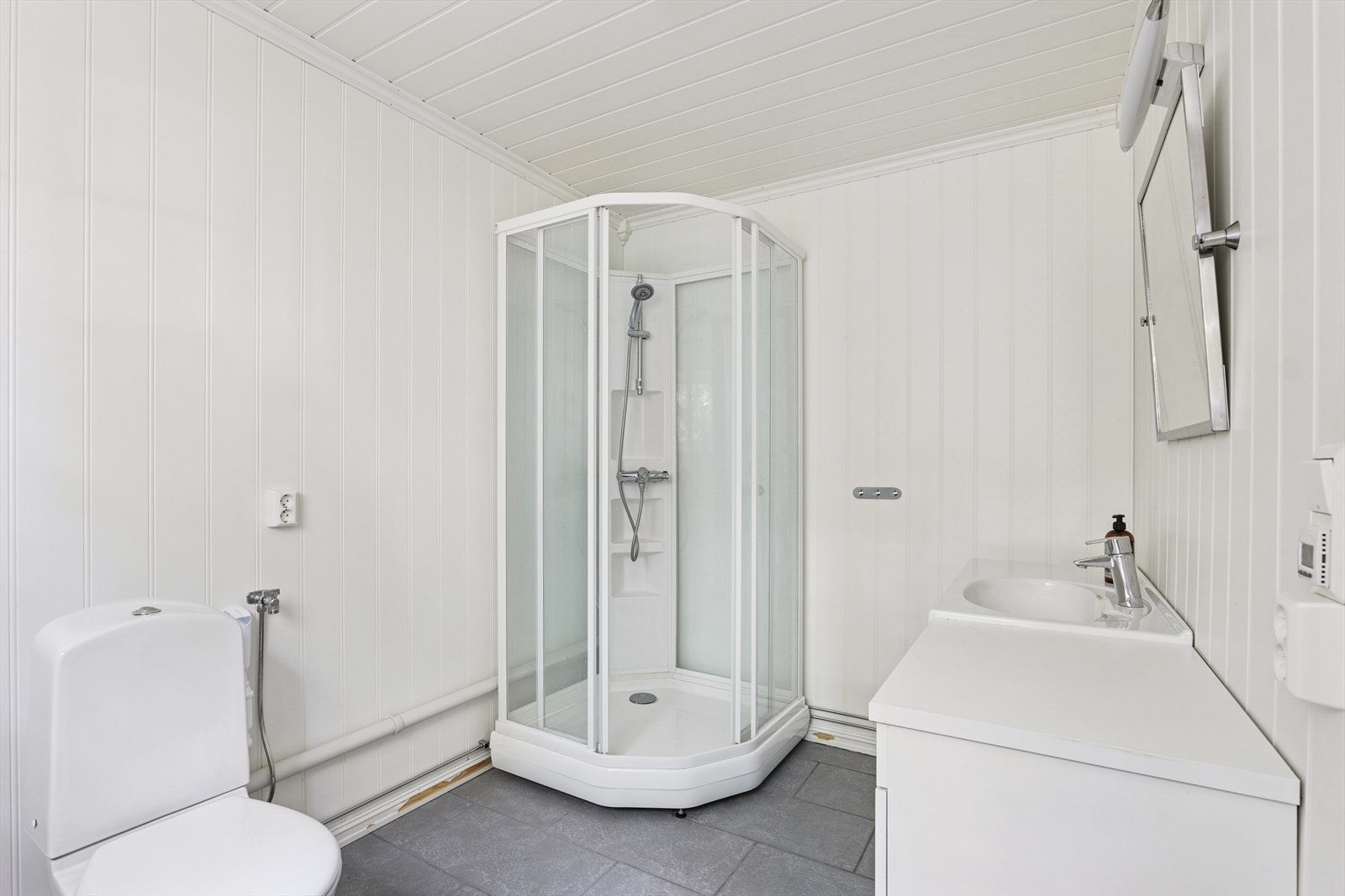 Baderommet i tilbygget er fra 2010 og inneholder dusjkabinett, heldekkende servant på innredning og toalett. Galleribilde