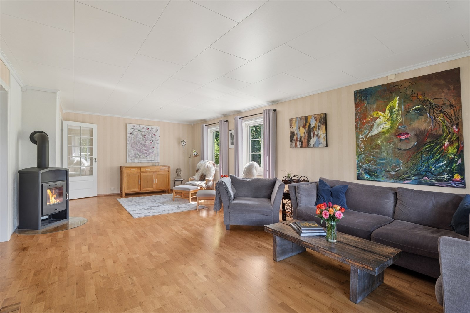 Midt i rommet står en vedovn som både varmer og skaper en hyggelig stemning. Galleribilde