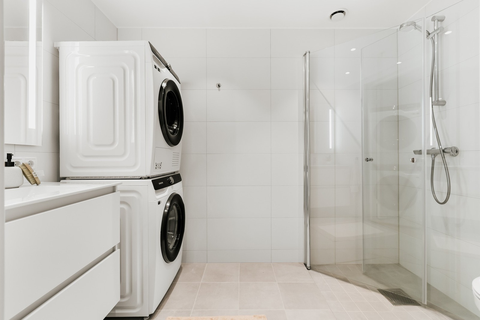 Rommet har innredning med nedfelt servant, veggmontert toalett, dusjvegger/hjørne og opplegg for vaskemaskin. Galleribilde