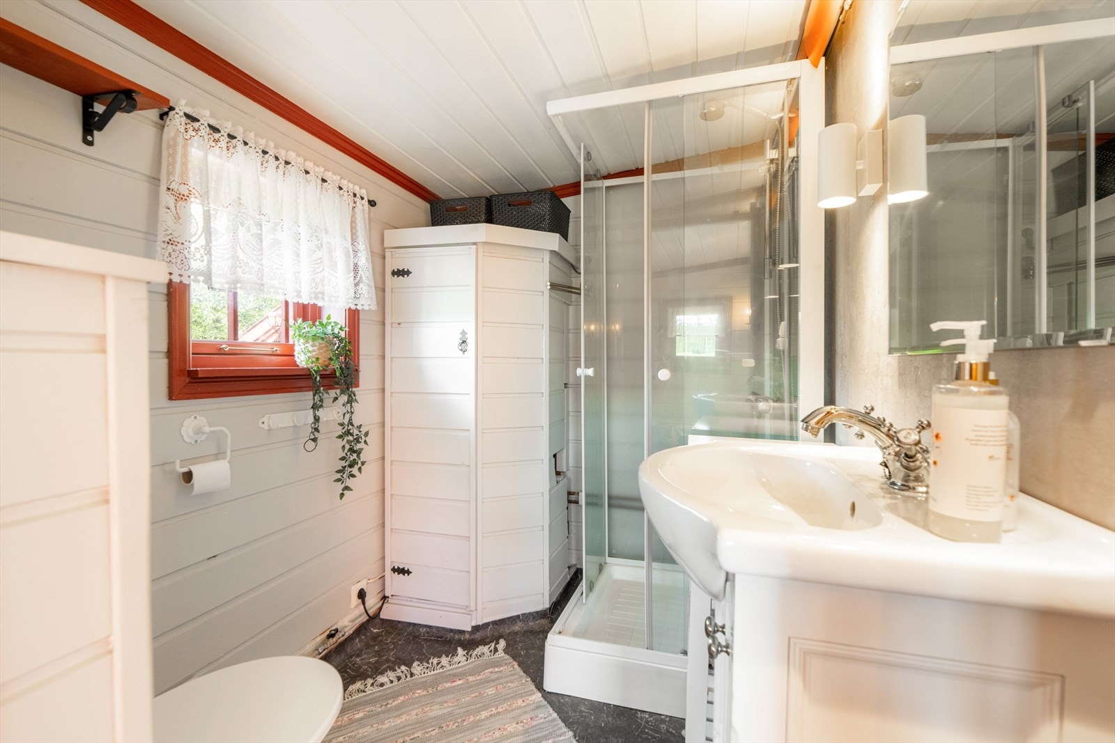 Bad fra 2019 med vinylbelegg på gulv og trepanel/ baderomsplater på vegger. Her er det toalett, dusjkabinett og innredning med heldekkende hvit vask, underskap med profilerte fronter og speil.
Det er varmekabler i gulvet og naturlig ventilering. Galleribilde