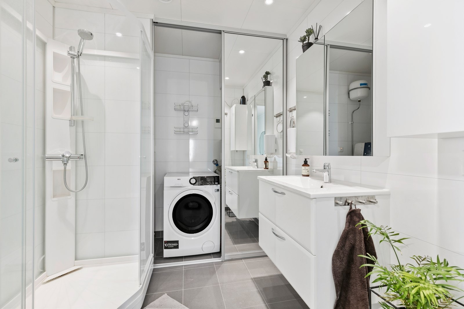 Badet har en lekker og tidløs utførelse. Her finner man eget "vaskerom" i en smart nisje inne på badet. Galleribilde